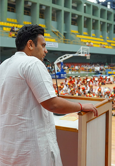 Man speaking at a podium in a stadium